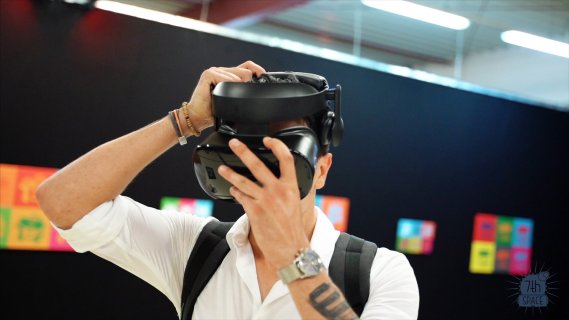 Ein Mann justiert seine VR-Brille mit den Händen.